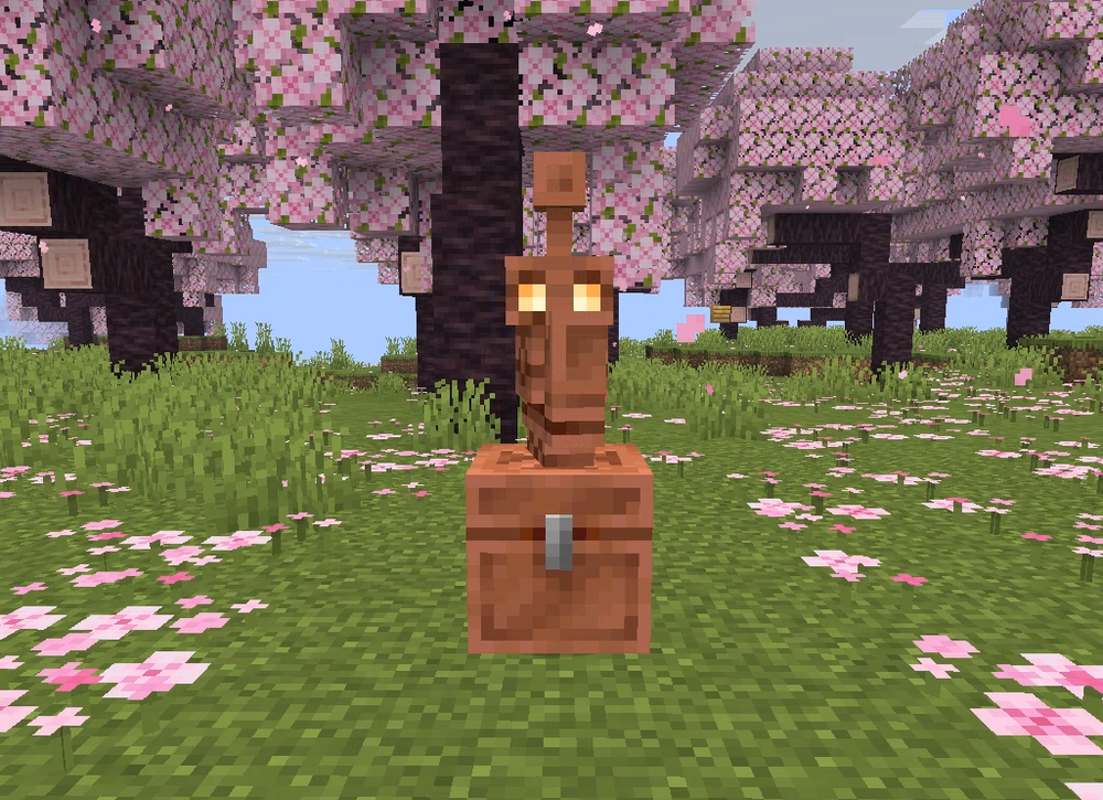 A Minecraft scene with a Copper Golem on a chest surrounded by blooming cherry blossom trees and grass.