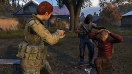 A tense DayZ gameplay scene where one player points a handgun at a kneeling hostage while another player in a balaclava watches in a rural village setting.