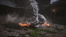 The monkey protagonist in Black Myth: Wukong battling the Macaque Chief boss, who is surrounded by a swirling snow effect and orange embers.