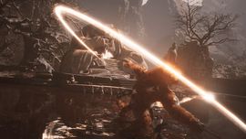 The Destined One in Black Myth: Wukong performing a powerful circular staff strike, leaving a bright glowing orange energy trail in a dark rocky environment.