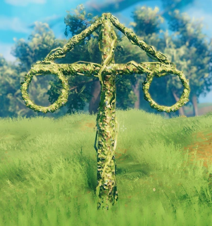 Valheim maypole decoration standing in a grassy Meadows biome, covered in green vines with two circular wreaths hanging from its crossbeam.