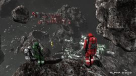 Two astronauts in space suits—one in green and one in red—standing on a dark, craggy asteroid surface while overlooking a fleet of small spacecraft in Space Engineers.